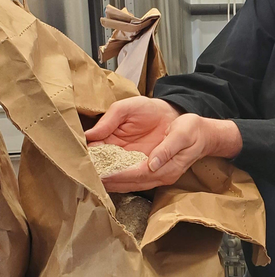 hands holding grain from a brown bag