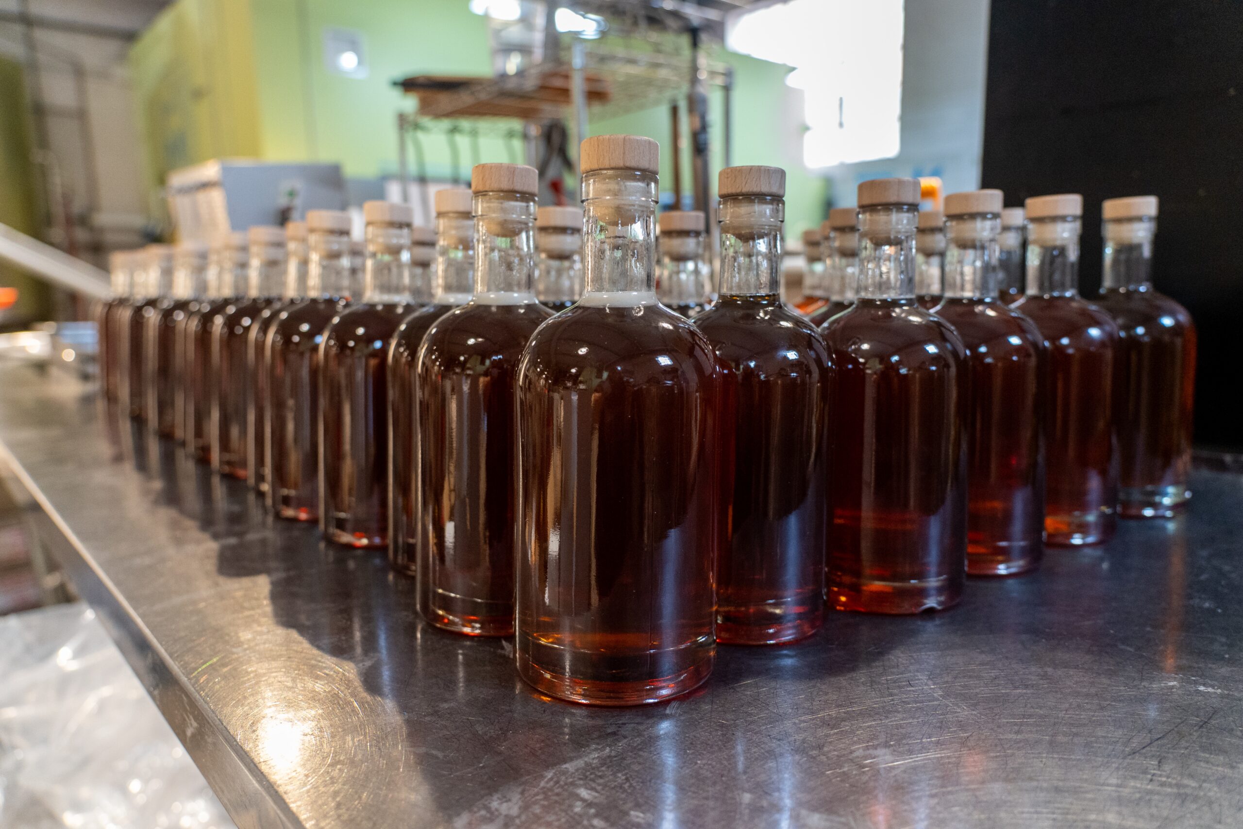 rows of unlabeled filled and corked bottles