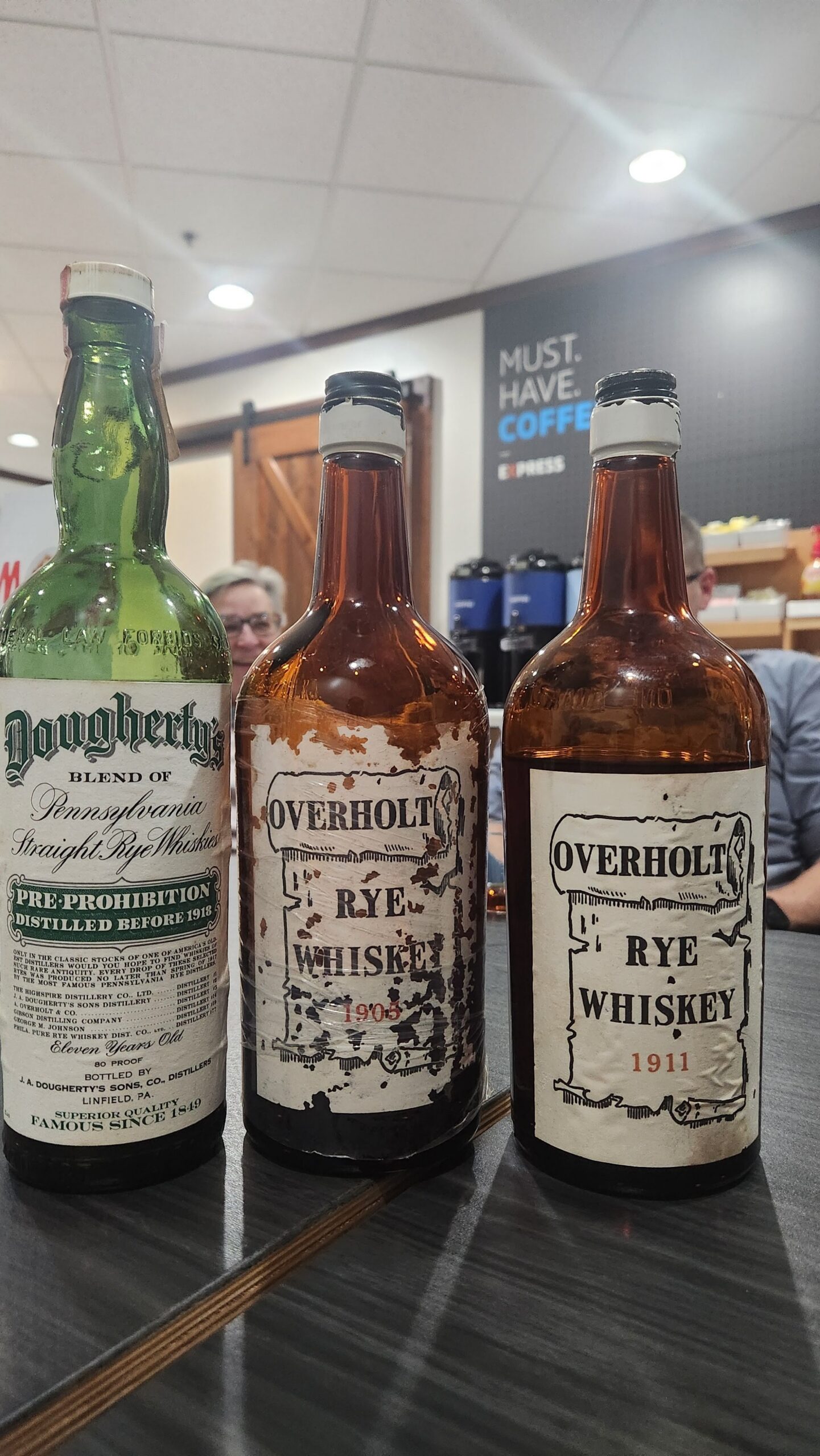 three bottles of rye whiskey lined up along a counter