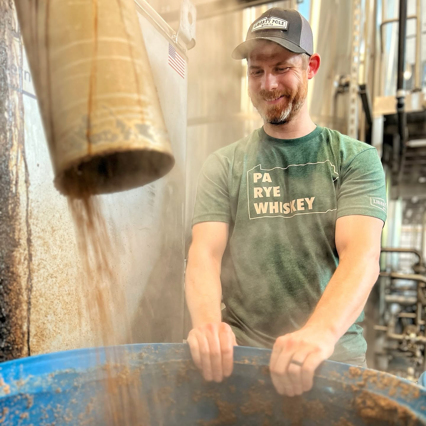 man wearing a pa rye whiskey shirt working with grain